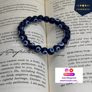 "Elegant Evil Eye bracelet placed on an open book, featuring protective eye motifs and a stylish design."